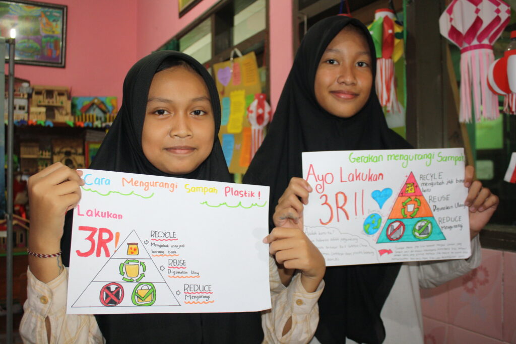 Meningkatkan Kesadaran Bahaya Mikroplastik bagi Kesehatan dan Pembelajaran Anak (2) Dua siswi MIN 1 Sidoarjo memegang poster edukasi tentang bahaya sampah plastik dengan pesan untuk melindungi lingkungan, termasuk mengurangi pencemaran laut oleh plastik.